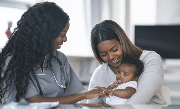 A doctor and a mother holding a small baby.